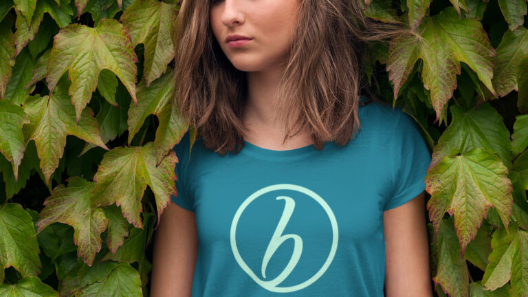 A woman wearing a shirt with the Her Breakthrough logo on the chest