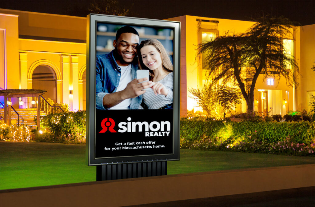 A photo of a road sign advertisement showing a happy couple looking a phone with the text "Simon Realty: Get a fast cash offer for your Massachusetts home."