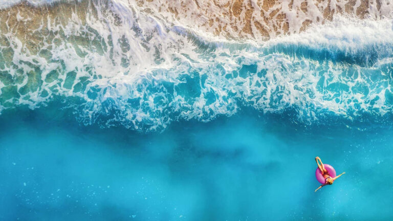 A photo of a girl relaxing in the ocean just off of the shore